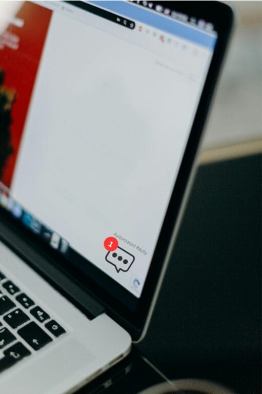 Laptop screen displaying a notification for an automated reply message with a red alert icon.